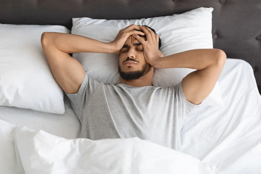 man waking up with headache