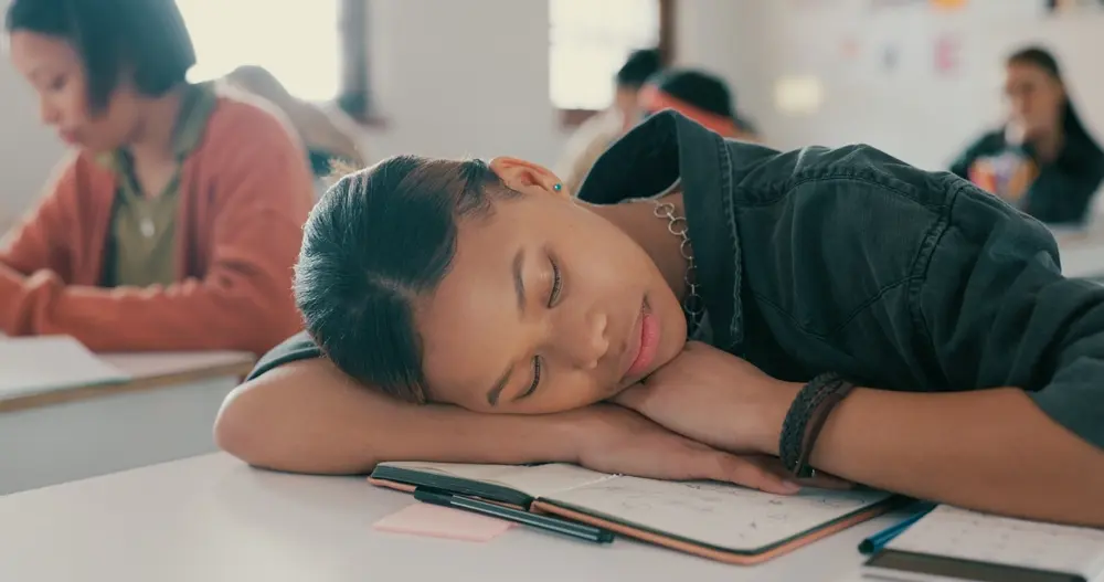 Young woman sleeping in classroom