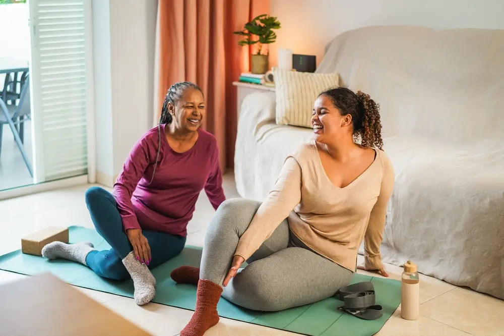 Mother and daughter doing stretching exercises on mat