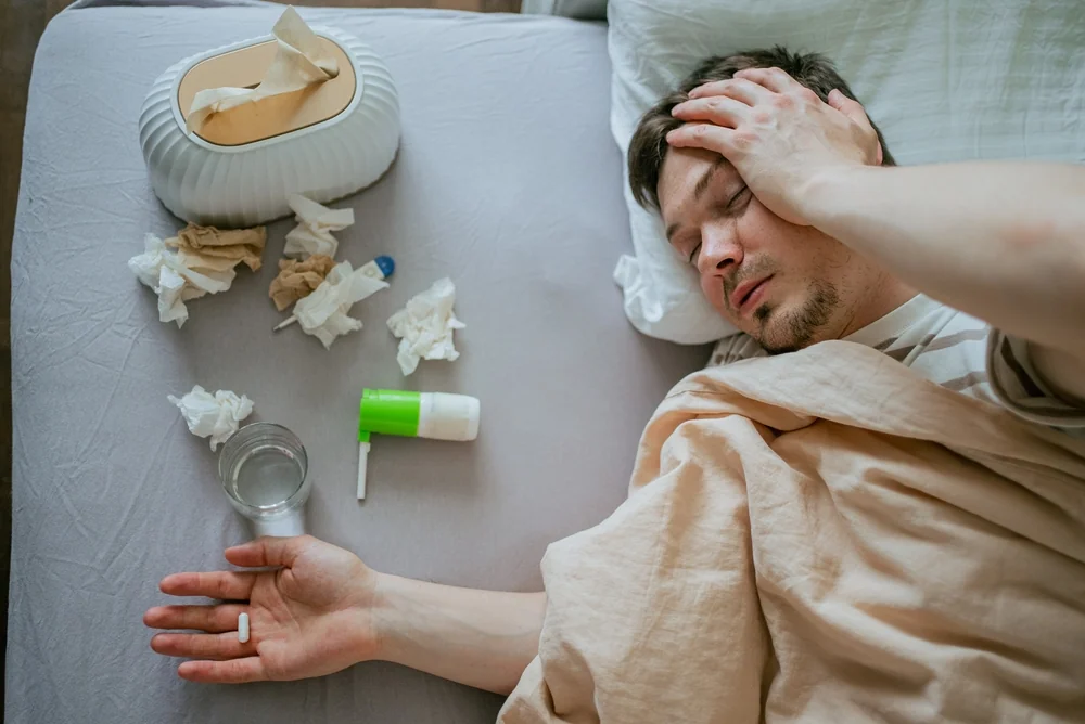 Man lying in bed with colds