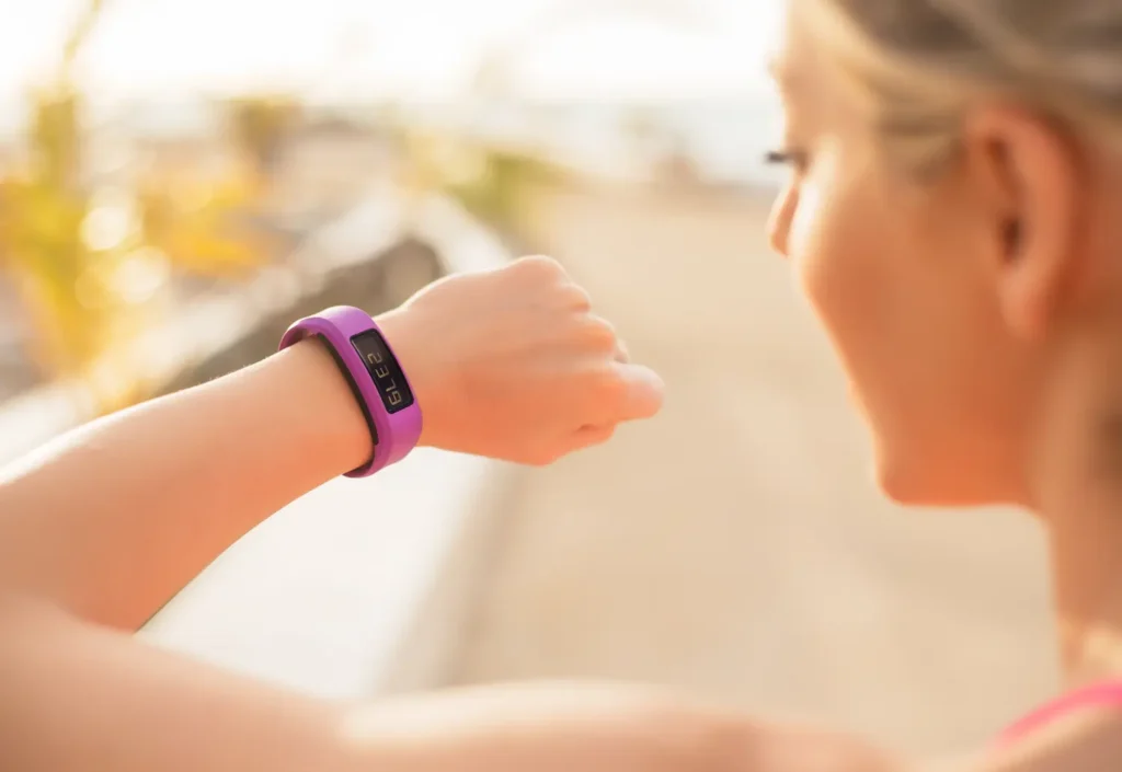 A woman checking her fitness tracker, representing the use of wearable technology in decentralized clinical trials for metabolic health.